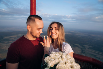 Handsome man confessed in love to his beautiful girlfriend in air balloon flight. She said yes and show engage ring on her hand. Original proposal of marriage