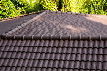 Brown natural tile roof. Modern types of roofing materials. Roof of the house, Natural roof tile against the blue sky. Building.