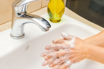 A Hands with soap are washed under the tap with water. Clean from infection and dirt and virus. At...