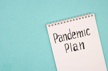 a white notebook with the words pandemic plan. the concept of building a different plan because of the coronavirus pandemic