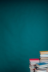 many stacks of educational books in the university library on a green background