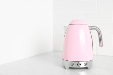 Modern electric kettle on counter in kitchen. Space for text