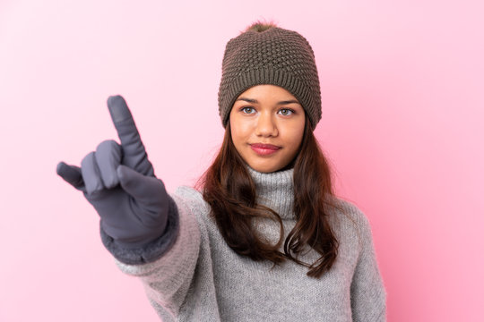 Young Colombian girl with winter hat over isolated pink wall touching on transparent screen