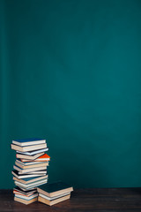 many stacks of educational books in the university library on a green background