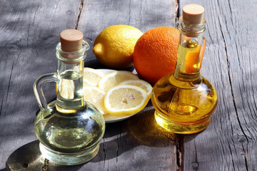 Olive oil and sunflower oil in decanter on a brown wooden table. Limons and garlic on a wooden...