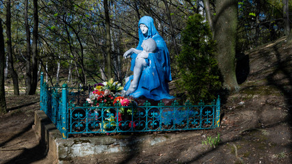Posąg chrześcijański w parku przedstawiający Maryję trzymającą w ramionach zdjętego z krzyża Jezusa.