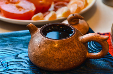 clay teapot full of tea on the wooden tray