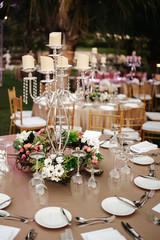 International Wedding outdoor celebration party under palm trees. Served tables on green area in hotel. Landyard. Beige and pink colors. Close-up and wide angle.