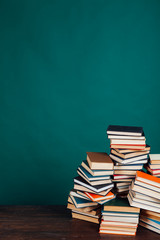 many stacks of educational books in the university library on a green background
