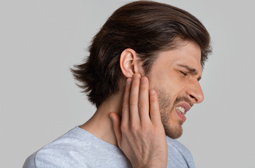 Fototapeta premium Man with ache holding ear, empty space