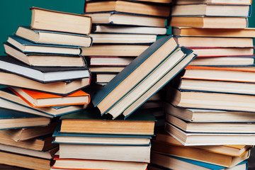 many stacks of educational books in the university library on a green background