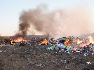 man burns a mountain of garbage