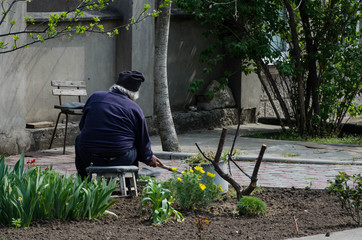 A man works at home. A man works in a garage. Household. A woman and a man clean a flower bed.