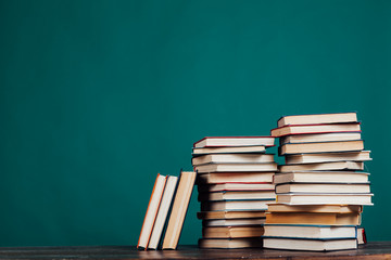 many stacks of educational books in the university library on a green background