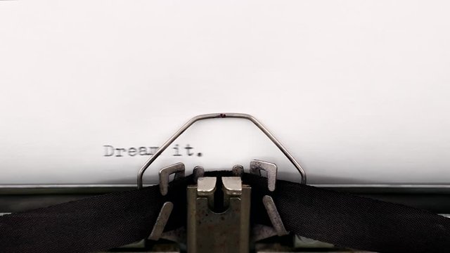 Typing a motivational quote dream it wish it do it on a vintage typewriter