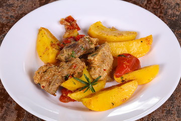 Baked pork meat with potao and tomato