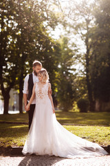 Obraz na płótnie Canvas Happy married couple in simple wedding dresses. Wedding couple. Stylish newlywed couple. Stylish white dress on the bride. Marriage concept.