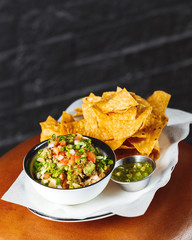 Plate of quacamole with tortilla chips. Spice starter. Vertical shot for instagram stories promo
