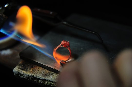 Craftsman is working by using a Gas spraying tool to make a ring