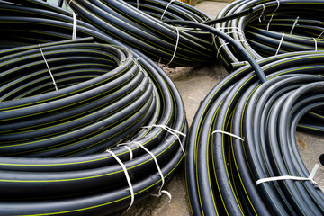 gas polypropylene pipe in rolls on the street, black plastic pipes