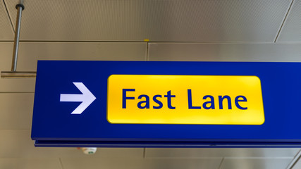 Fast Lane sign in blue and yellow at the airport close up. Fast Lane sign airport first class luxury notification.