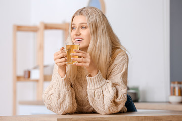 Beautiful young woman drinking tea at home