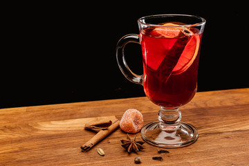 Glass of mulled wine with spices on a wooden Board 