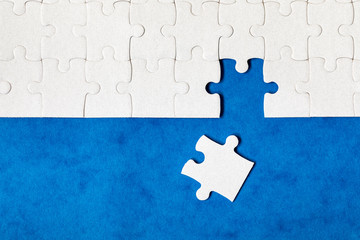 White jigsaw puzzle. White puzzle pieces on color background. Unfinished white jigsaw puzzle pieces...