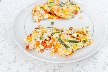 Omelet with vegetables. Baked omelet with vegetables. Omelet close-up. The dawn. Eating Green beans, carrots, peas, peppers, corn. Ready omelet.