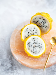 Golden dragon fruit on stone desk and light grey marble background. Exotic tropical fruits top view.
