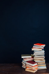 many stacks of educational books in the university library on a black background