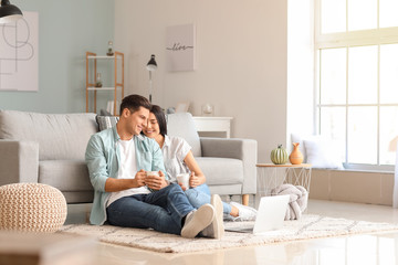 Happy young couple with laptop at home