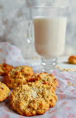 Oatmeal cookies and a glass of milk. Light wooden background. Healthy sweet breakfast. Free space for text. Close up. Vertical view