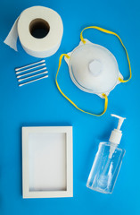 Health care safety kit for Coronavirus Covid-19 prevention concept.  Flat lay on blue with mask, hand sanitizer, gloves, toilet paper, cotton.