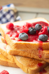 Toasted bread with sweet raspberry and blueberry jam for breakfast