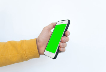 Man's hand holding a smartphone with a vertical green screen. Isolated on white background. Yellow sweater. Copy space