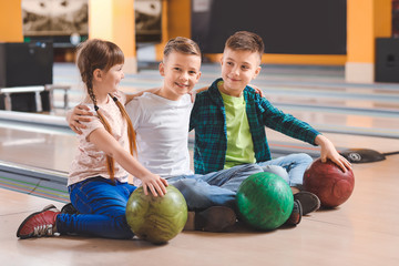 Little children playing bowling in club