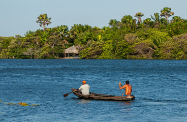Canoe with two fishermen on the Preguiças River, in Lençois Maranhenses National Park, Barreirinhas, Maranhao, Brazil on October 13, 2006. In the background, natural vegetation-2.jpg, Canoe with two