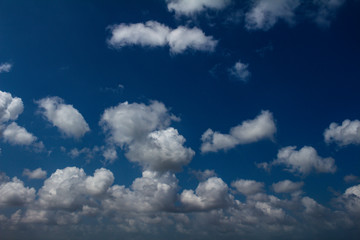 Beautiful clouds scattered across the blue sky. Small, cottony white clouds.