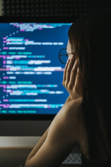 Young female programmer writes program code on a computer. home office