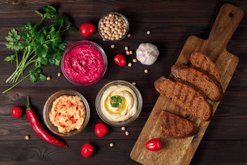 Variety of Middle eastern hummus with chickrea, beetroot, carrot on wooden table