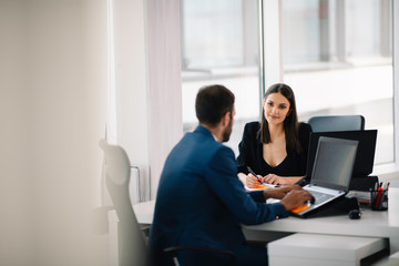 Colleagues working together in office. Young businessman and businesswoman working on project.	
