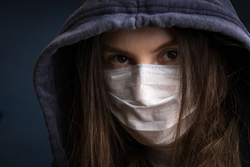 a girl in a medical mask with a hood on her head