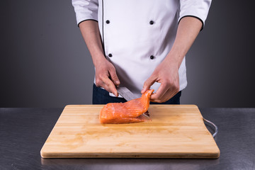 chef cuts salmon for fresh sushi in a restaurant kitchen4