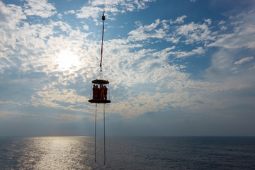 Offshore transportation. Offshore workers.A Silhouette of offshore crew hanging in the middle of...
