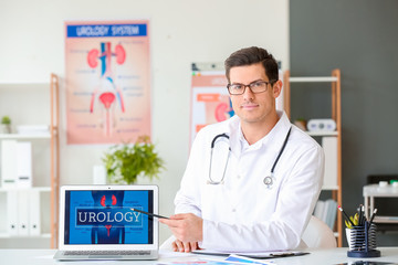 Portrait of young urologist with laptop in clinic