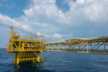 Oil and gas platformOil and gas industry. A yellow well head platform complete with safety device and facilities in the middle of the sea.