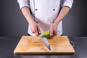 chef cuts and cleans a ripe avocado in the restaurant kitchen2