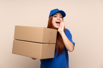 Young teenager delivery girl over isolated background shouting with mouth wide open