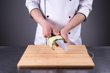 chef cuts cucumber in the restaurant kitchen10